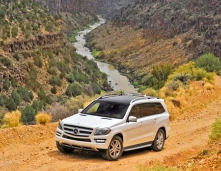 White 2013 Mercedes-Benz GL350 driving through the country.