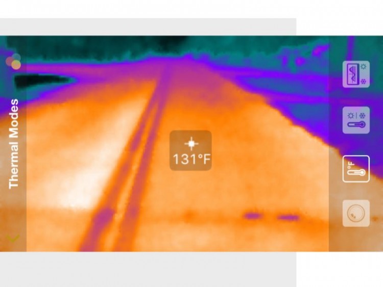 Screenshot of asphalt roadway with surface temperature reading.