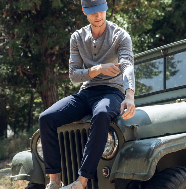 Model wearing Olivers Apparel Passage Pant, sitting on the front of a Jeep