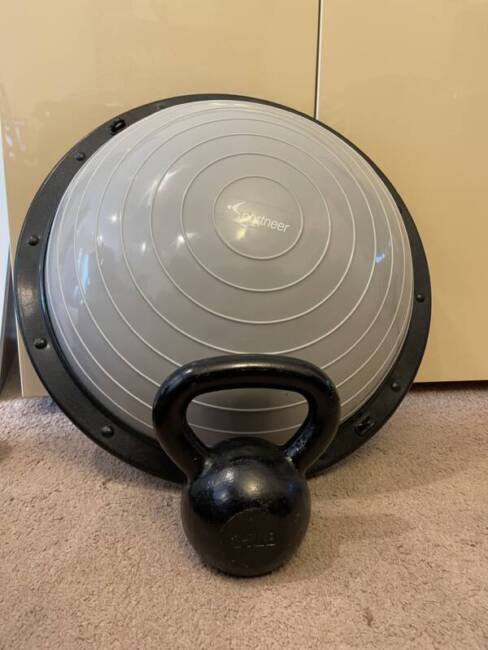 Sportneer Half Balance Ball next to a 25 -pound kettle ball