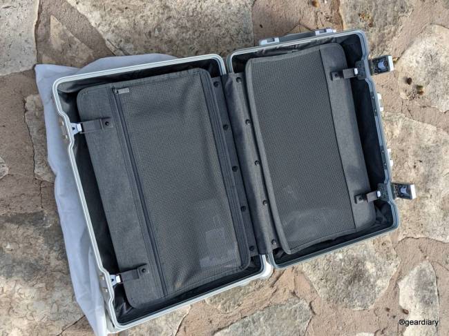 20" LEVEL8 Gibraltar Full Aluminum Carry-On laying on ground open, showing the compression dividers 