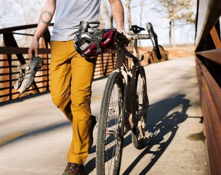 Man wearing LIVSN Flex Canvas Pants walking his bicycle