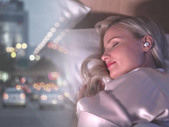 Woman sleeping with a pair of QuietOn 3 Sleep Earbuds in her ears.
