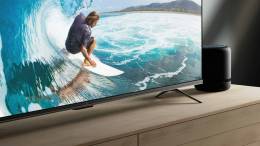 A Amazon Fire TV Omni with a man surfing a big wave on the screen