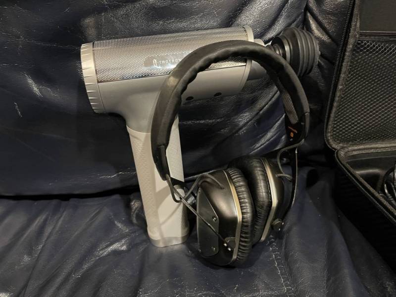 Taotronics 10 Speed Massage Gun next to V-Moda headphones for scale