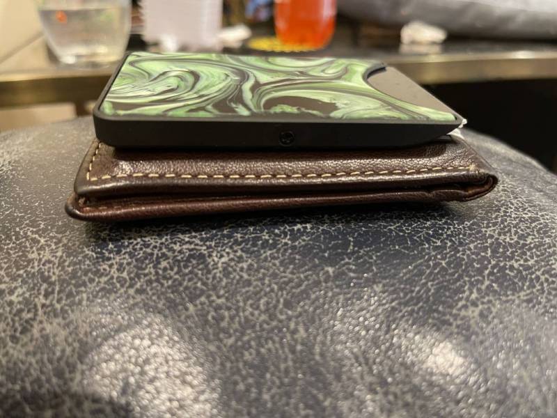 Carved Alloy Wallet on top of the author's bi-fold wallet for size comparison