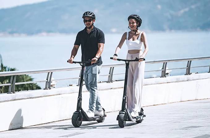 A man and a woman riding a pair of MAXFIND G5 PRO electric scooters
