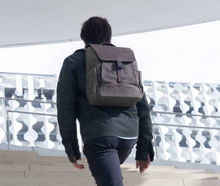 A man walks up a flight of stairs with the WaterField Miles Laptop Backpack on his back. 