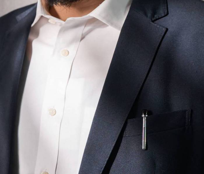 A bearded person wearing a white shirt and a blue blazer; in the left breast pocket, there is a Adonit Star Stylus with the clip showing over the pocket's edge. 