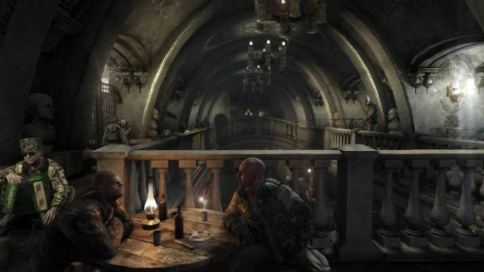 A scene from the game "Metro 2033 Redux" of two characters talking in a dark room while a third character keeps watch