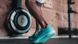A muscular pair of legs seen in a gym wearing a pair of Neon Blue No Bull Trainer Plus