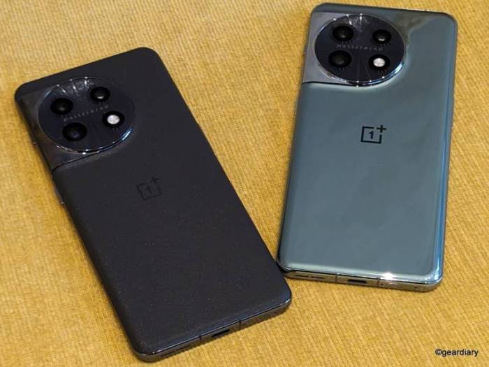 Two OnePlus 11 5G smartphones shown lying facedown; on the left is the black on, and on the right is the green. 