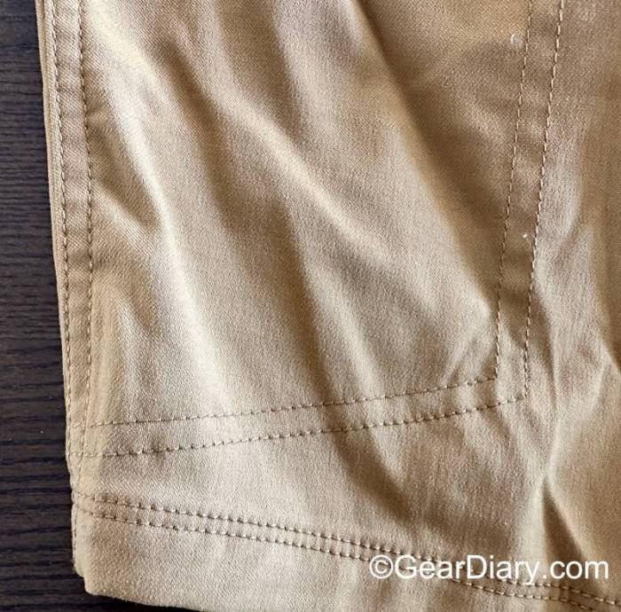 Reinforced stitching on the left front hem and pocket on a khaki colored pair of LIVSN Ecotrek Trail Shorts