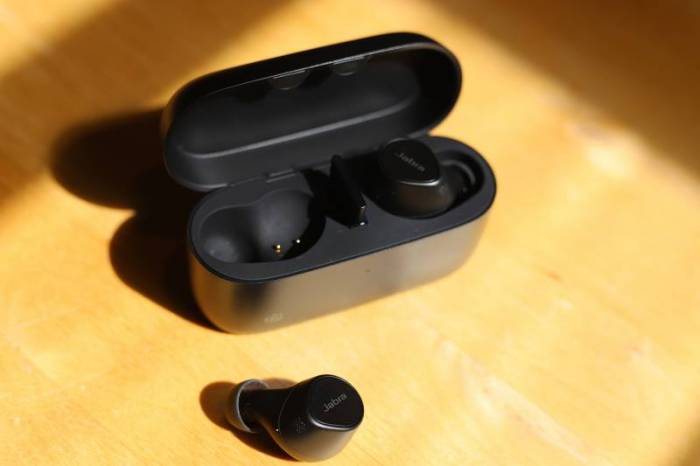 The open Jabra Evolve2 True Wireless Earbuds charging case with the left earbud resting on the table