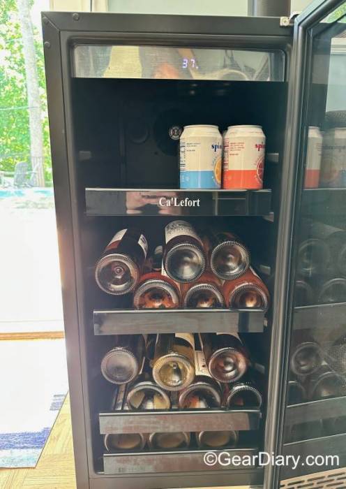 A Ca'Lefort 15" 100-Can Beverage Refrigerator loaded with bottles of wine and canned beverages