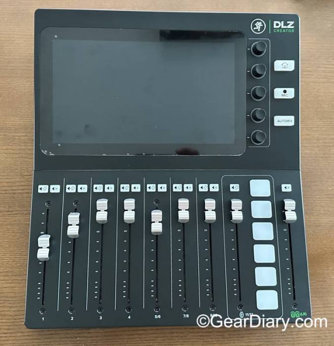 The Mackie DLZ Creator has a large touchscreen display on top with control knobs and sliding buttons on the bottom. 