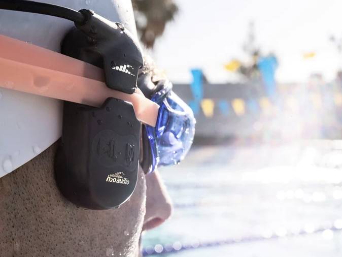 H2OAudio SONAR PRO clipped to a man's swim goggles