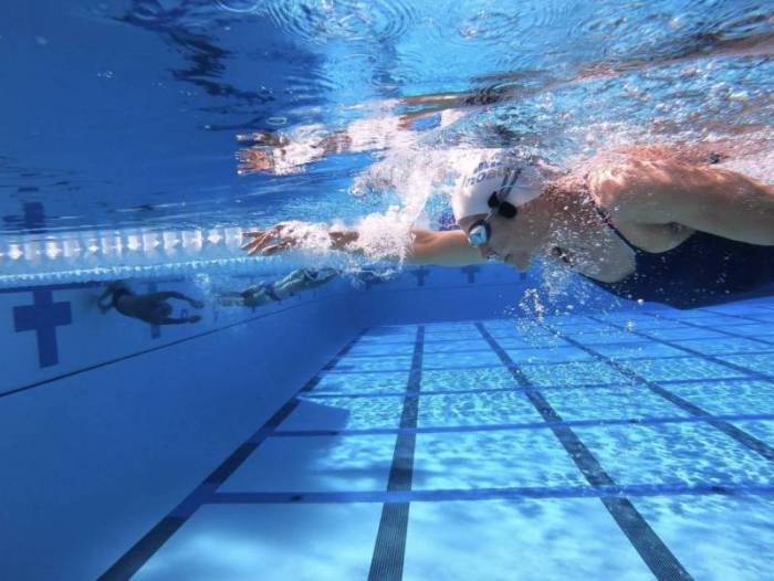 Woman swimming while wearing the H2OAudio SONAR PRO