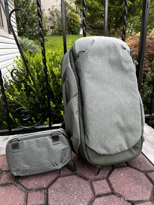 Peak Design Travel Backpack 30L and Travel Pouch in Sage Green, shown leaning against a black wrought iron porch railing