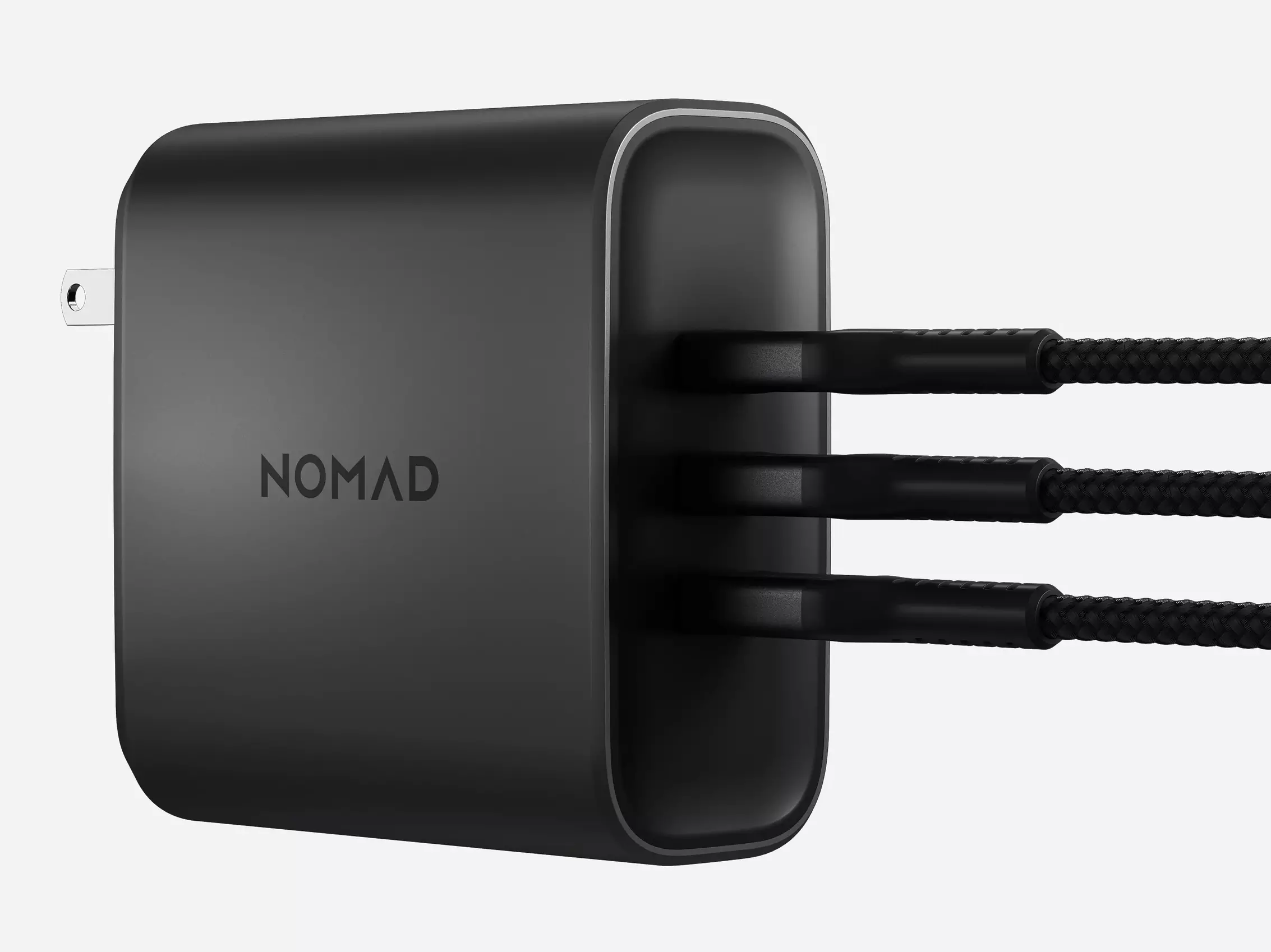 Angled front view of the Nomad 130W Power Adapter in Carbide with three USB Type-C cables plugged in