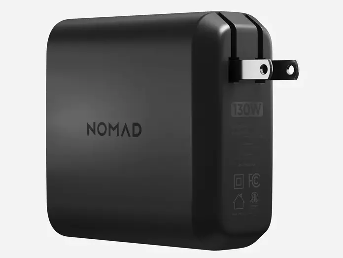 Angled side view of the Nomad 130W Power Adapter, showing the folding AC plug