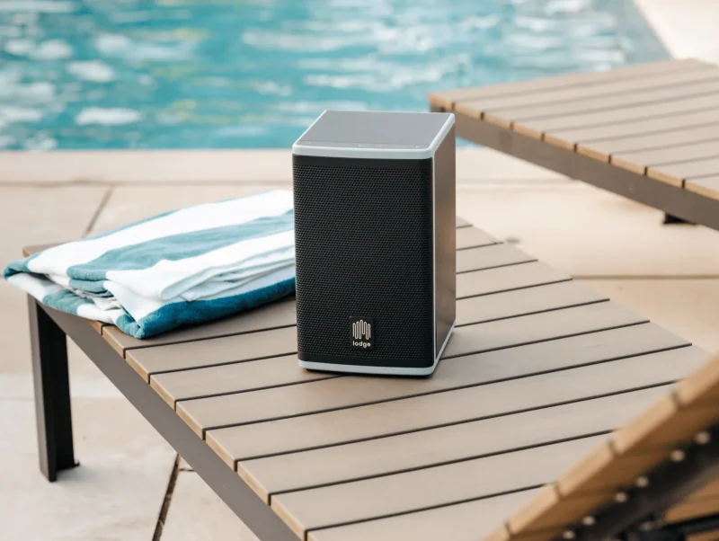 solar-powered lodge Speaker 4 Series sitting on a pool-side lounger