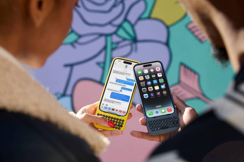 Two people holding iPhones with Clicks creator keyboards; yellow on the left, and blue on the right