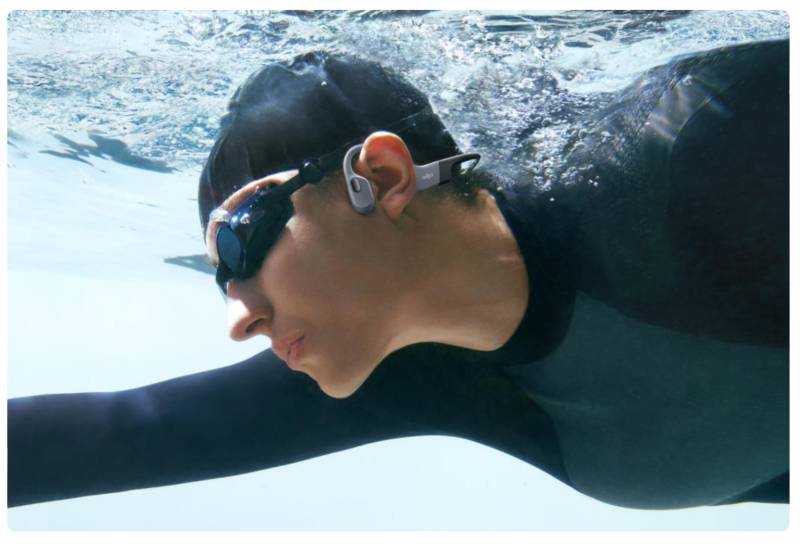 Man swimming while wearing Shokz OpenSwim Pro