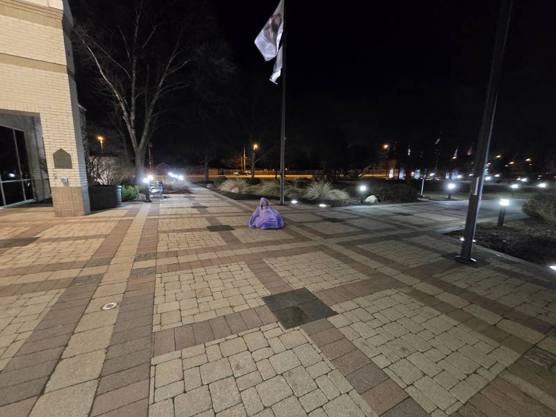 A woman sits on the ground.