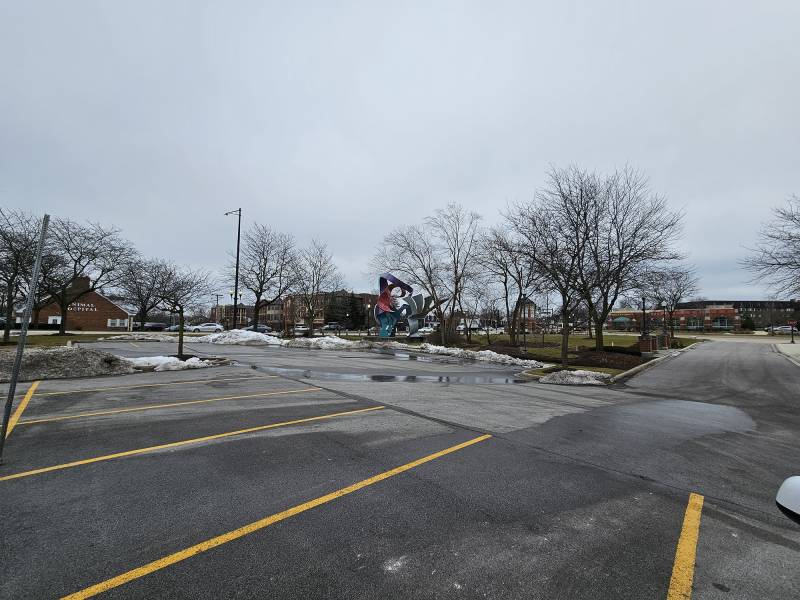 A sculpture sits just outside a parking lot.