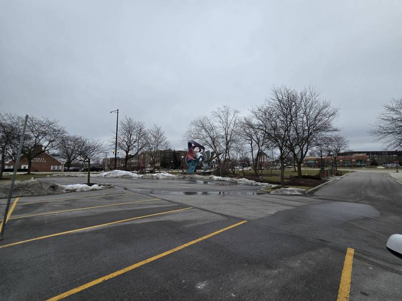 A sculpture sits just outside a parking lot.