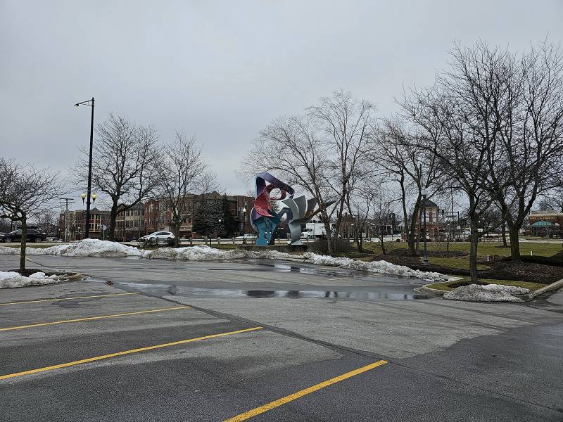 A sculpture sits just outside a parking lot.