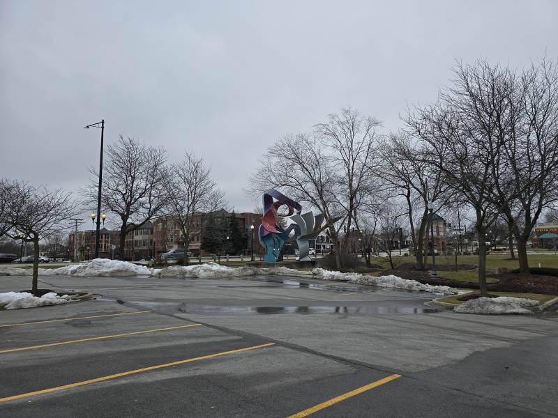 A sculpture sits just outside a parking lot.