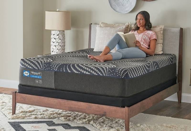 woman lounging on a Sealy Posturepedic Plus Hybrid mattress