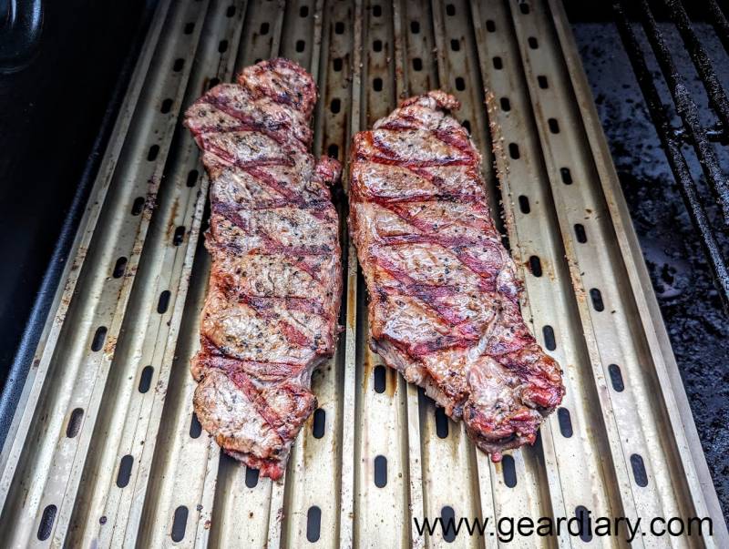 Steaks cooking on the ridged side of the Traeger ModiFIRE Sear Grate.