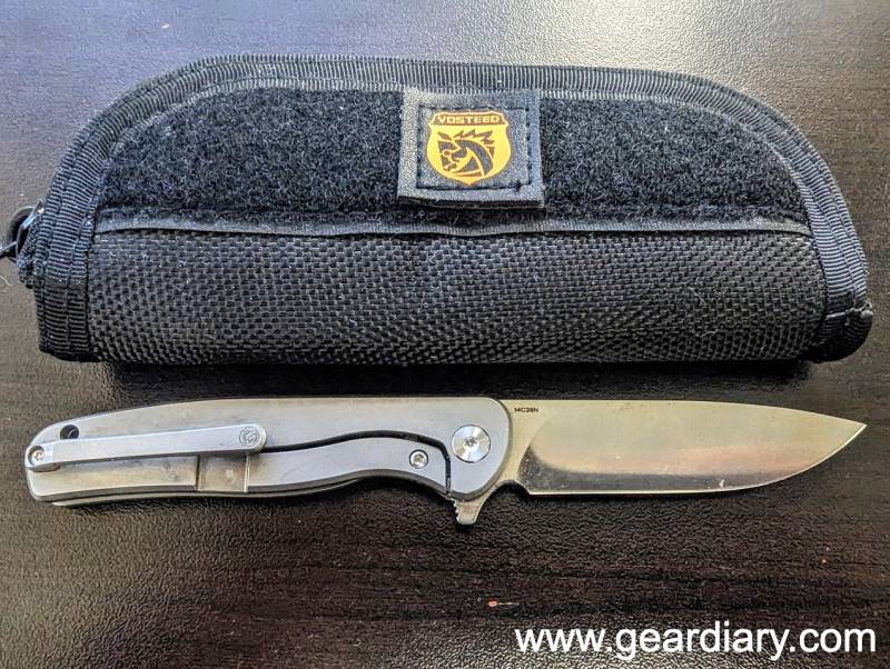 The Vosteed Mini Labrador Lock Knife opened in front of its black cordura nylon carry case.