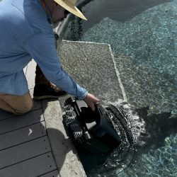 Kev slipping the Beatbot Aquasense Pro into the water