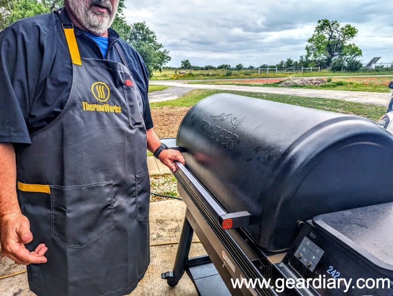 The author wearing the ThermoWorks x Hedley & Bennett Apron while standing in front of a Traeger Ironwood pellet grill. 