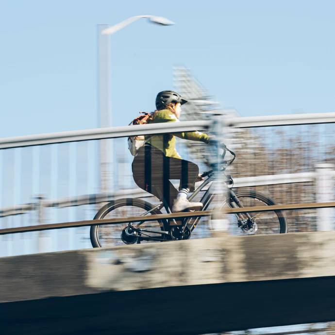 Man riding across a bridge on the Vvolt Alpha 2.