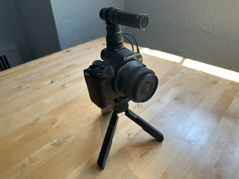 The Canon EOS R50 with microphone and tripod attached.