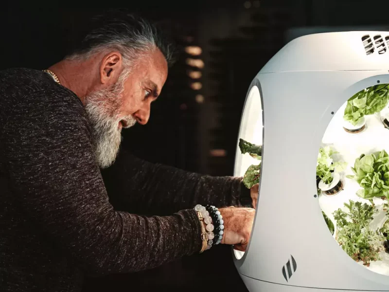 Man picking vegetables out of the Plantaform Smart Indoor Garden