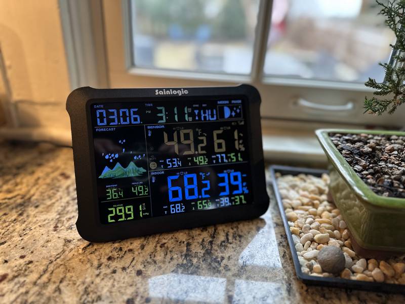 Sainlogic SA1 Wi-Fi Smart Weather Station sitting on a counter near a window