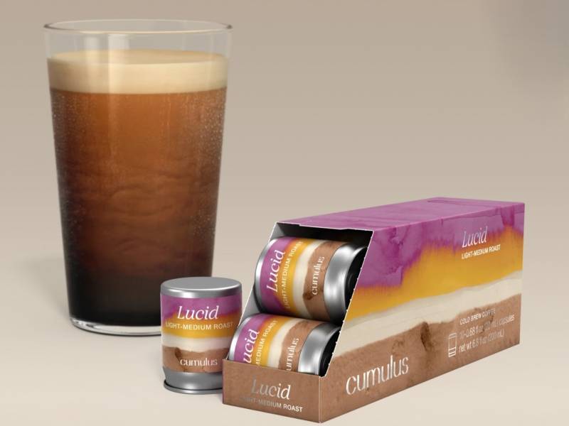 Lucid Coffee Capsules next to a glass of Cold Nitro Coffee. 