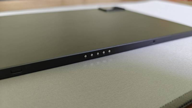 View of the magnetic pogo pins on the bottom of the nubia Pad Pro sitting on a gray mat