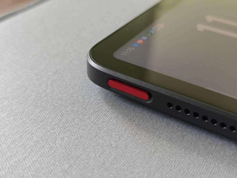 Closeup view of the red power button on the nubia Pad pro sitting on a gray desk mat