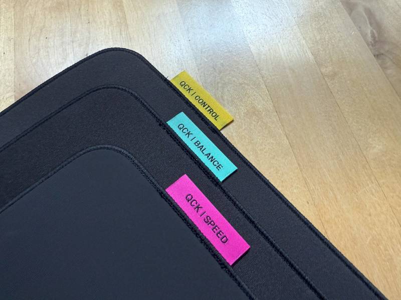 A stack of the Speed, Balance, and Control SteelSeries QcK Performance Series Mousepads