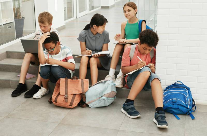 Photo of middle school students hanging out on steps at school. 