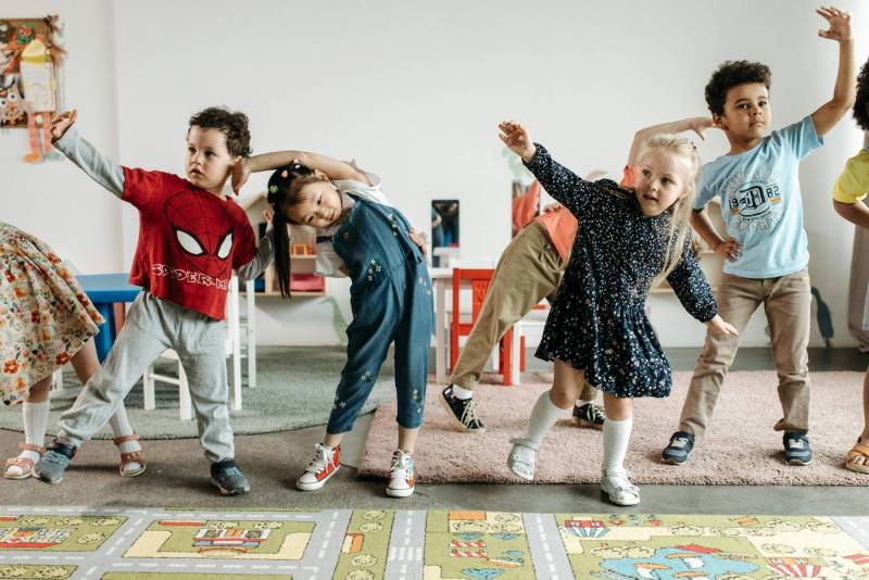 Photo of young children dancing in classroom.