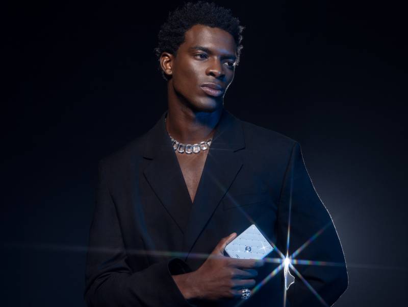 The Brilliant Collection - man in a dark suit holding a glittery motorola razr
