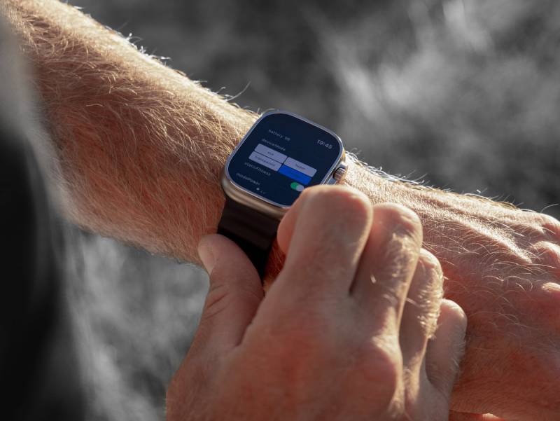 Hypershell X Ultra Exoskeleton Will Allow You to Hike Farther, Cycle Easier, and Conquer Any Terrain 4 Man adjusting modes on his Hypershell X Ultra using an Apple Watch.